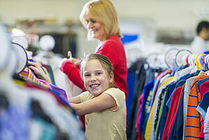 Kind lacht bei einem Kleiderbörse