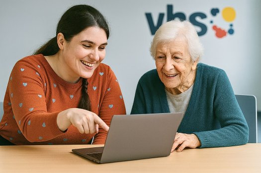 Eine junge und eine alte Frau sitzen an einem Laptop. 