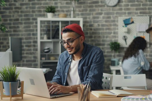 Ein Mann sitzt an einem Schreibtisch.