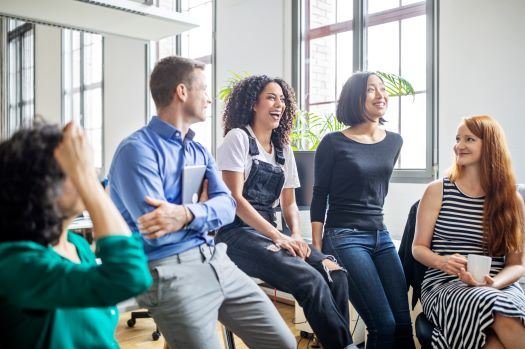 Eine Gruppe Menschen sitzt zusammen und lacht. 